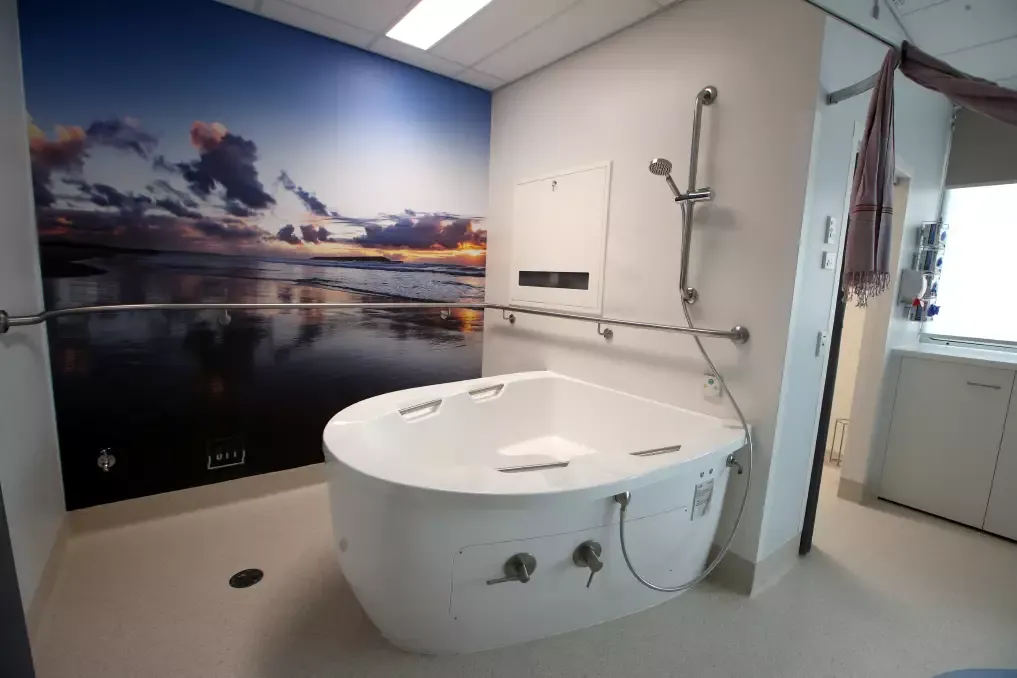 AQVA maternity bath in a hospital birth suite with a coastal mural