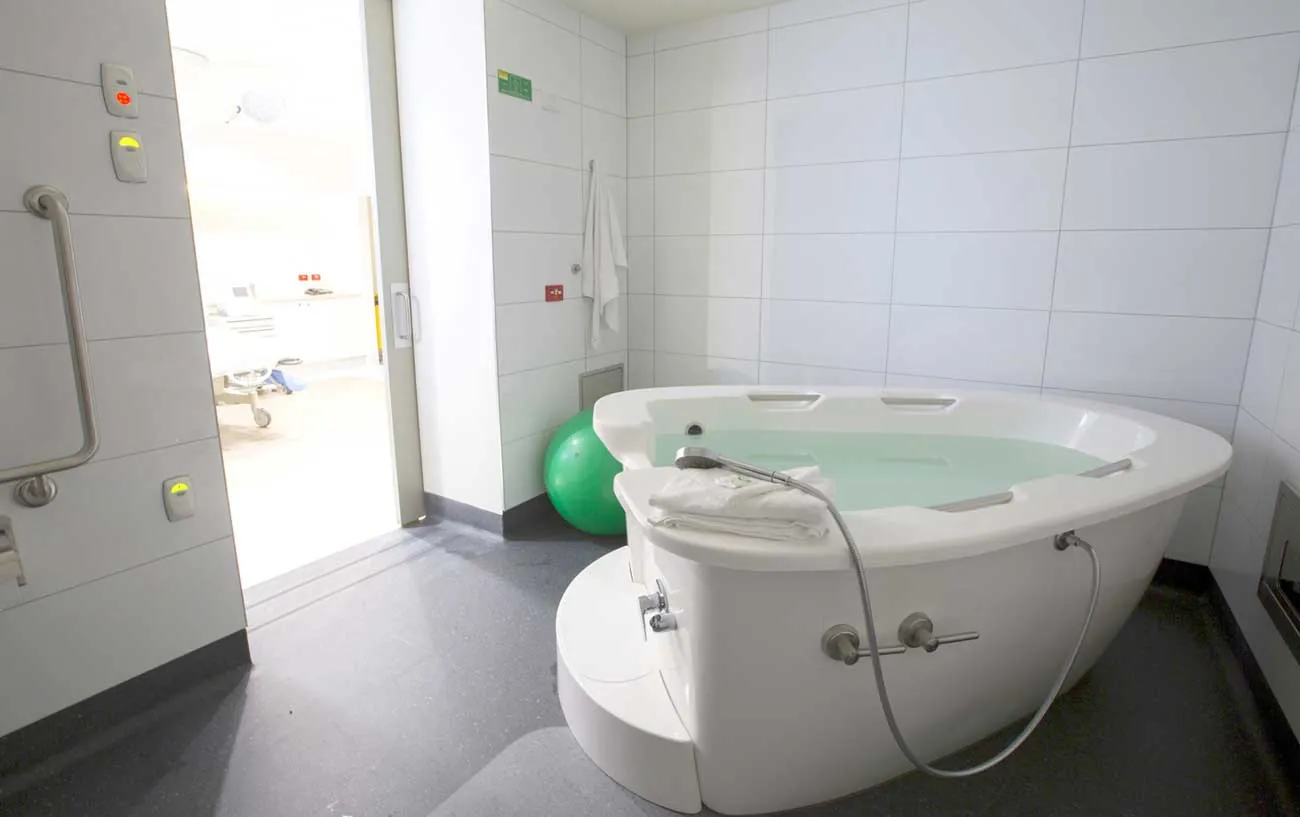 AQVA maternity bath filled, in a tiled hospital birth suite