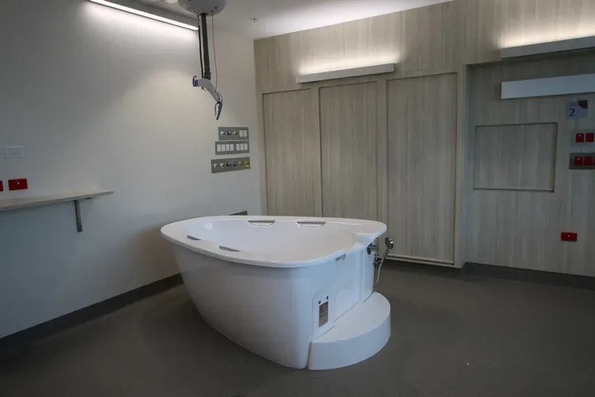AQVA maternity bath in a hospital birth suite with timber-panelled walls